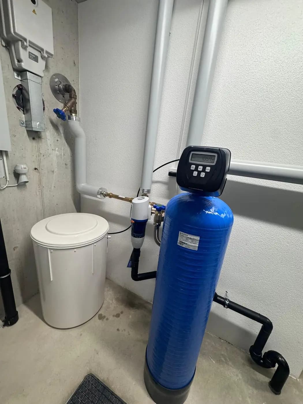 Wasserenthärter mit Salzbehälter und Vorfilter, sauber an die Hausinstallation angebunden